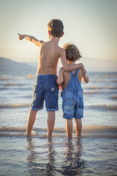 男孩和女孩站在海滩上
